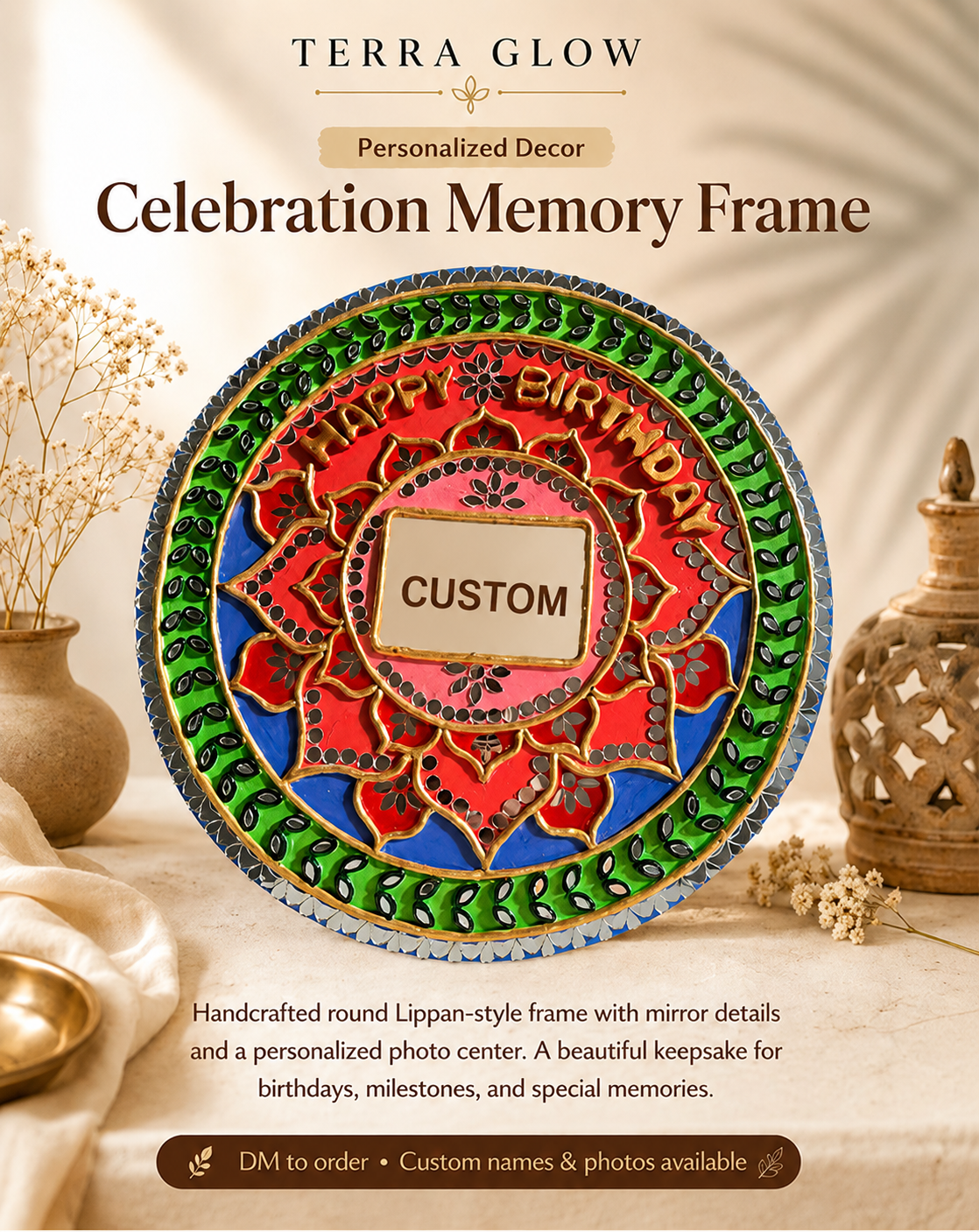 A colorful round personalized lippan-style memory frame from Terra Glow, featuring a red and blue floral design with green borders and a customizable photo center, styled on a beige fabric surface with dried flowers and decorative lanterns.